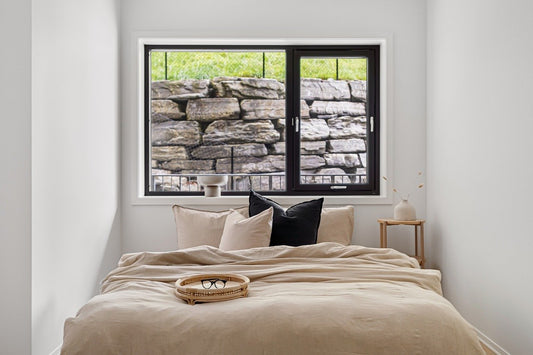 hemp bed sheets and duvet cover in natural wheat color on bed with window view